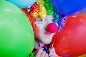 Clown with a bunch of colorful air balloons.